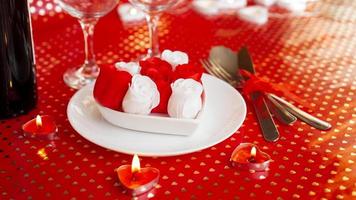 un piatto bianco con vino, coltello e forchetta su uno sfondo rosso brillante