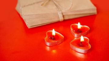 buste di carta kraft con candele rosse su sfondo rosso. foto