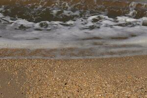 io amato il Guarda di il oceano In arrivo in il spiaggia qui. il mare schiuma lentamente lavaggio al di sopra di il bella ciottoli alcuni di quale Guarda piace gemme e siamo traslucido tutti molto liscio a partire dal essere caduto. foto