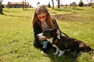 la giovane donna in occhiali da sole rossi gioca con il suo corgi foto