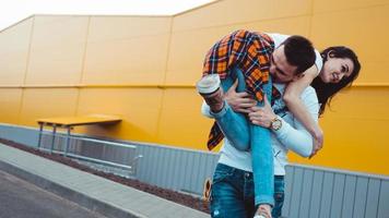 uomo felice che porta la sua ragazza su sfondo giallo foto