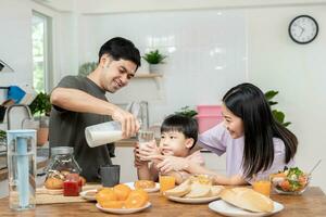 famiglia volta, colazione, attività insieme durante il vacanze. genitori e bambini siamo avendo un' pasto insieme durante il vacanze. nuovo casa per famiglia su mattina, divertiti, fine settimana, vacante tempo foto