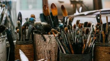 tavolo con pennelli e strumenti in laboratorio d'arte. sfondo. foto