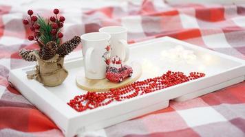 tazza rossa di capodanno o natale su vassoio bianco a letto con luci foto