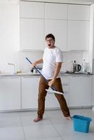 uomo che pulisce casa con il mocio
