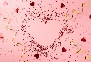 cuore rosso coriandoli a forma di cuore vista dall'alto piatto su sfondo rosa