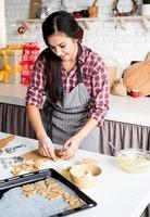 giovane donna bruna che cuoce i biscotti in cucina