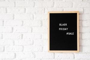 testo vendita venerdì nero su cartoncino nero su muro di mattoni bianchi foto