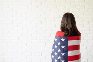 bella giovane donna con bandiera americana, vista posteriore foto