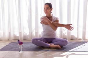 giovane donna che allunga la sua spalla dopo la pratica dello yoga foto