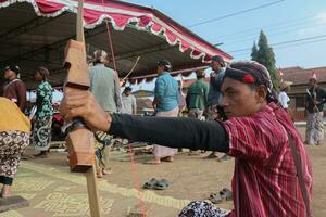 Klaten, Indonesia, agosto 15, 2023. maschio e femmina partecipanti, vestito nel giavanese costume tirato il suo arco di strabismo per raggiungere concentrazione di bersaglio precisione nel tradizionale giavanese freccia trad. foto