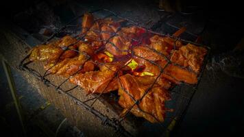 grigliato pollo o ayam pangang grigliato al di sopra di caldo fuoco carbone. Indonesia cibo foto
