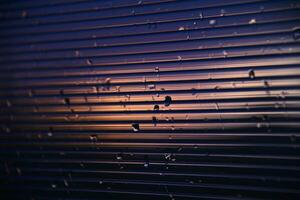 blu-viola policarbonato con gocce di pioggia. Visualizza di bagnato bicchiere nel il ambientazione sole. foto