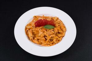 penne pasta con pollo, pomodori decorato foto