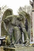 un' statua di un angelo seduta su un' lapide foto