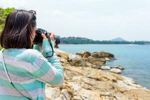 giovane donna fotografia vicino il mare foto