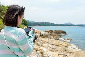 giovane donna fotografia vicino il mare foto