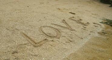 spiaggia sabbia scritto con il parola amore nel il mattina foto