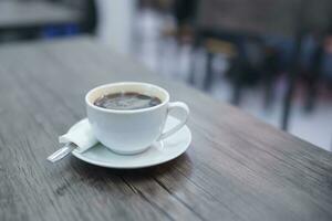 lato prospettiva caffè nel bianca tazza su di legno tavolo nel bar foto