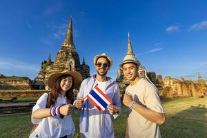 gruppo di turista su loro zaino in spalla con tailandese bandiera siamo in viaggio per antico tempio di Phra SI sanfeta tempio, ayutthaya, Tailandia per turismo e giro turistico foto