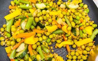 piatto di verdure con carote piselli cipolle fagioli su piatto bianco. foto