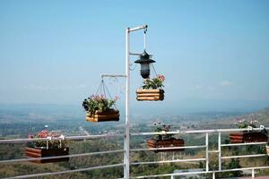 fioritura bianca e viola fiori nel di legno pentola sospeso con ferro polo nel naturale leggero giardino e blu cielo foto