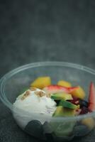 Yogurt con molti frutta nel un' plastica tazza per andare. foto