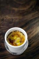 Tazza da dessert con crema catalana di mango tropicale sul tavolo di legno
