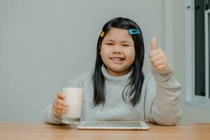 asiatico ragazza avendo latte prima letto sorridente felicemente foto