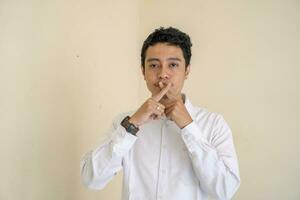 giovane indonesiano Riccio uomo indossare bianca Abiti con isolato bocca posa. foto