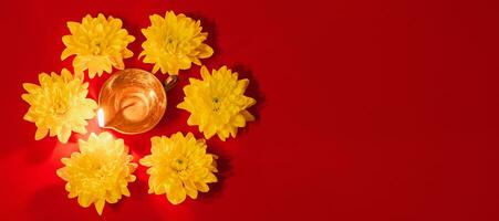 Diwali indiano leggero Festival. diya olio lampada e giallo fiori su rosso sfondo. tradizionale indù celebrazione. foto