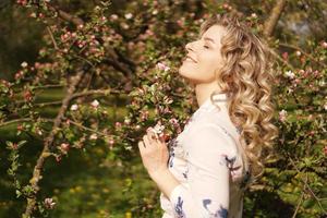 romantica giovane donna nel giardino primaverile tra i fiori di melo. foto