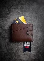 portafoglio in pelle marrone con testo vendita venerdì nero su etichetta e credito foto