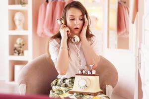 una donna sorpresa parla al telefono. cornetta del telefono in stile retrò foto