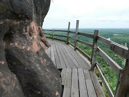 di legno ponte nel il boschi, di legno passerella su arenaria montagne a phu ok tempio, Tailandia, bellissimo scenario di di legno sentiero lungo il scogliera foto