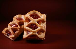 soffio Pasticcino Pasticcino con mirtilli rossi marmellata su un' buio rosso sfondo. biscotti con mirtilli rossi marmellata. foto