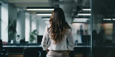posteriore Visualizza di donna d'affari in piedi nel moderno ufficio e guardare lontano. ai generato. foto