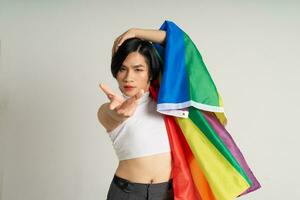 Immagine di asiatico gay uomo Tenere un' arcobaleno bandiera con fiducia in posa su un' bianca sfondo foto
