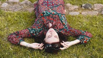 giovane donna sdraiata sull'erba. persone che si rilassano all'aperto. foto