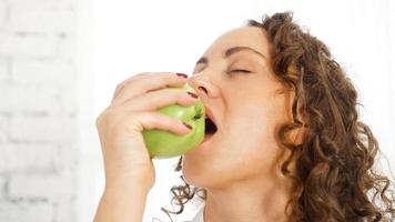 donna che mangia sano morde una mela verde foto