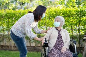aiutare una donna anziana asiatica su sedia a rotelle elettrica