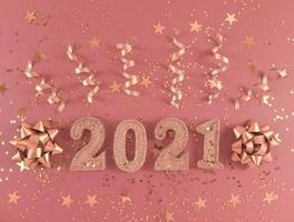 figure glitterate 2021, stelle, fiocchi e nastri su sfondo rosa. foto