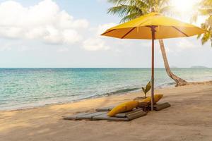 umbella e sedia a sfondo spiaggia estate tropicale.