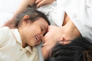 madre e figlia sdraiate su un letto foto