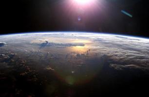 vista dell'orizzonte terrestre mentre il sole tramonta sull'oceano pacifico foto