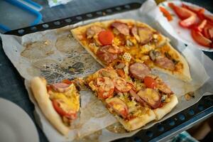 resti di un' affettato fatti in casa Pizza. incompiuto Pizza su tavolo a casa. Pizza su cottura al forno. foto