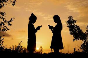 fare il furbo, silhouette di donna assunzione inteligente Telefono a tramonto foto
