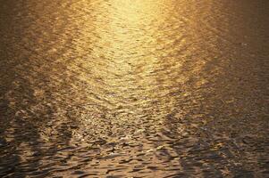 sfocato sfondo di superficie acqua nel il tramonto tempo foto