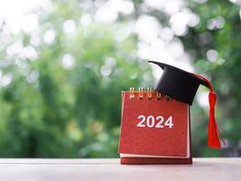 studia obiettivi, 2024 scrivania calendario con la laurea cappello. il concetto per risoluzione, obiettivo, azione, pianificazione, e gestire tempo per successo diplomato nel nuovo anno 2024 foto