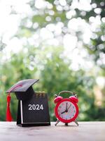 studia obiettivi, 2024 scrivania calendario con la laurea cappello e rosso allarme. il concetto per risoluzione, obiettivo, azione, pianificazione, e gestire tempo per successo diplomato nel nuovo anno 2024 foto